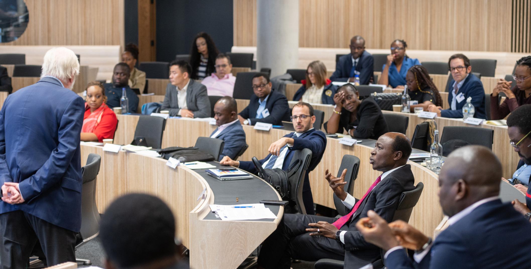 Executive course participants engaged in lively discussion in lecture theatre