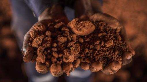 Hands holding bauxite in Guinea