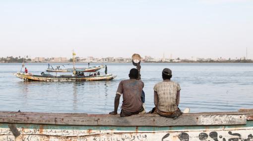 Two men sitting on the riverside in Saint Louis, Senegal